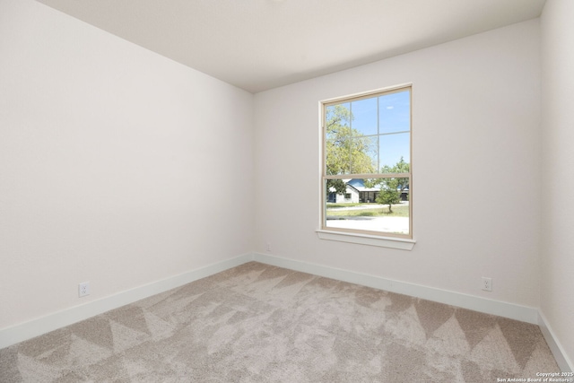 carpeted empty room featuring a wealth of natural light