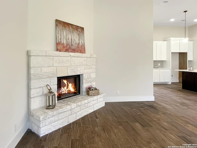 unfurnished living room featuring dark wood-type flooring and a fireplace