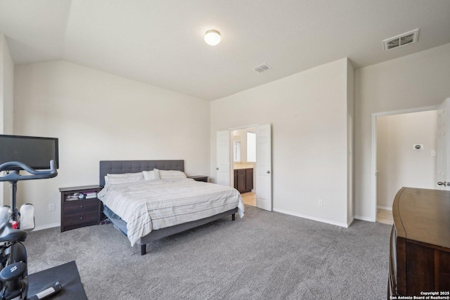 carpeted bedroom with ensuite bathroom and lofted ceiling