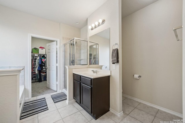 bathroom with walk in shower, vanity, and tile patterned flooring