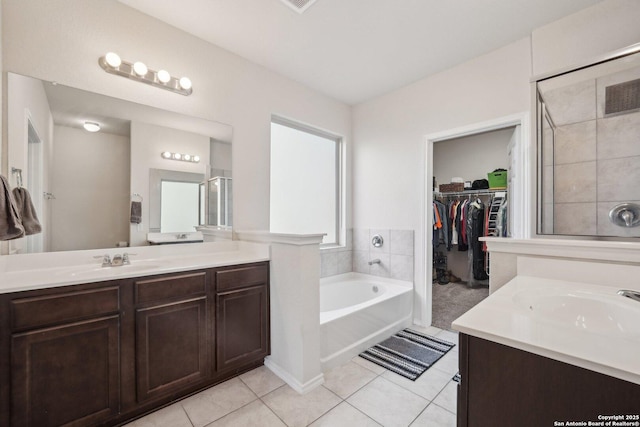 bathroom featuring a tub to relax in, vanity, and tile patterned flooring