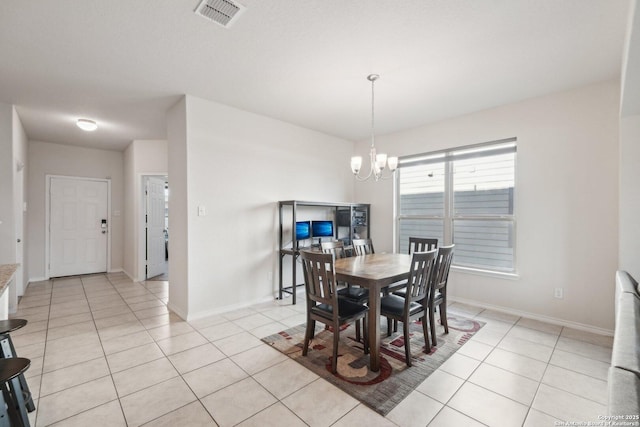 tiled dining space featuring an inviting chandelier