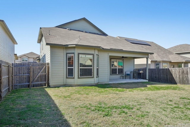 back of property with a patio area, a yard, and ceiling fan