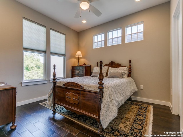 bedroom featuring multiple windows, dark hardwood / wood-style floors, and ceiling fan