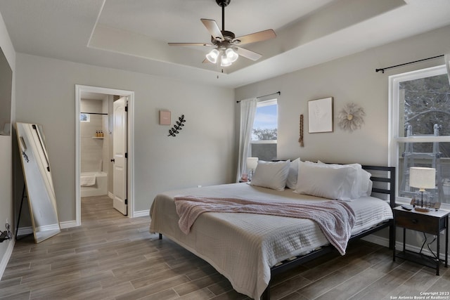 652 Canyon Bnd, Canyon Lake, TX 78133 - bedroom with ceiling fan, connected bathroom, and a tray ceiling