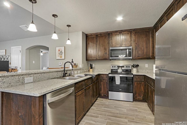 652 Canyon Bnd, Canyon Lake, TX 78133 - kitchen featuring sink, dark brown cabinetry, light stone countertops, and appliances with stainless steel finishes