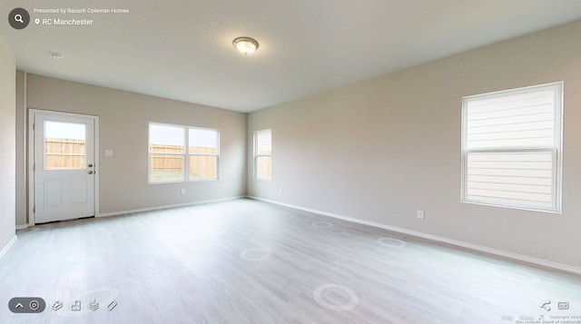 unfurnished room with light wood-type flooring and a wealth of natural light