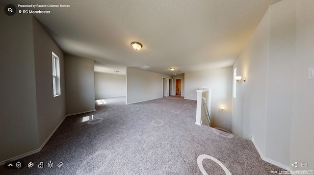 carpeted spare room with a textured ceiling