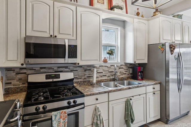 kitchen featuring backsplash, sink, white cabinetry, and appliances with stainless steel finishes