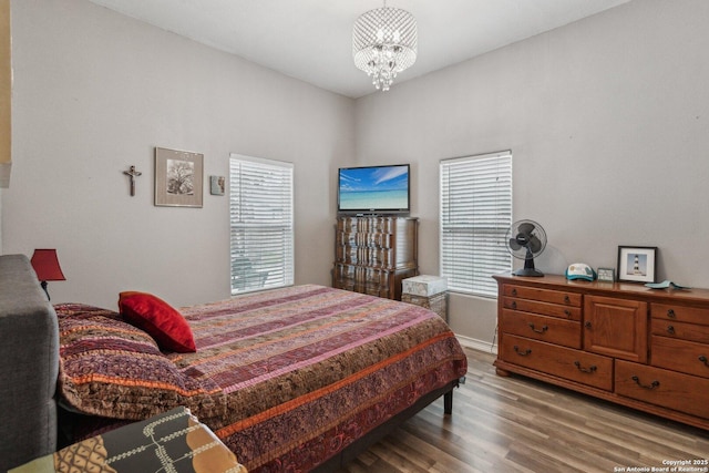 bedroom with a chandelier and hardwood / wood-style floors