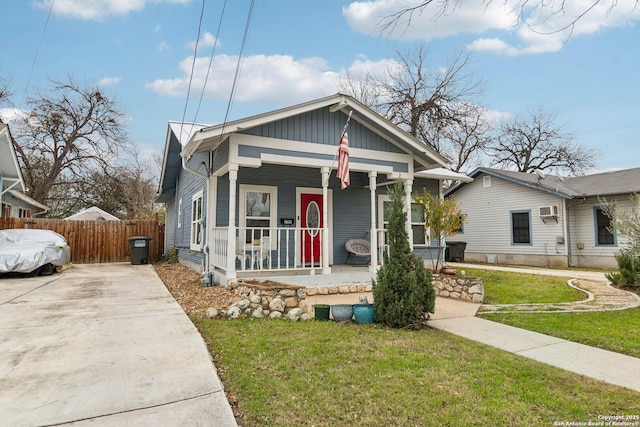 bungalow featuring covered porch and a front lawn