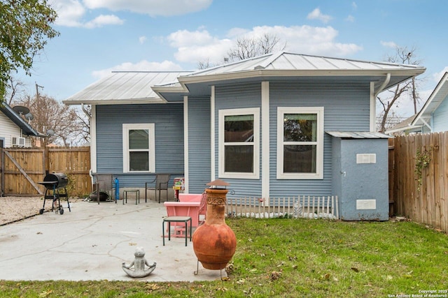 rear view of house featuring a lawn and a patio