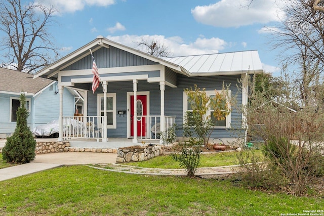 bungalow-style home with covered porch and a front yard