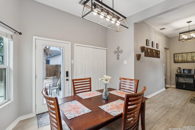 dining area with an inviting chandelier and light hardwood / wood-style floors