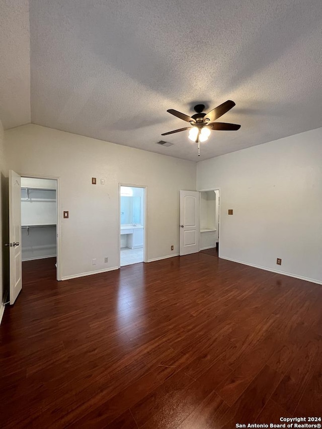 unfurnished room featuring lofted ceiling, a textured ceiling, ceiling fan, and dark hardwood / wood-style flooring