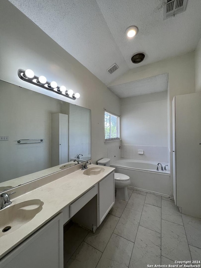 bathroom with a textured ceiling, vanity, toilet, vaulted ceiling, and a bathing tub