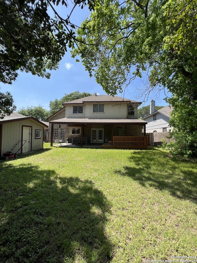 back of house featuring a storage shed and a lawn