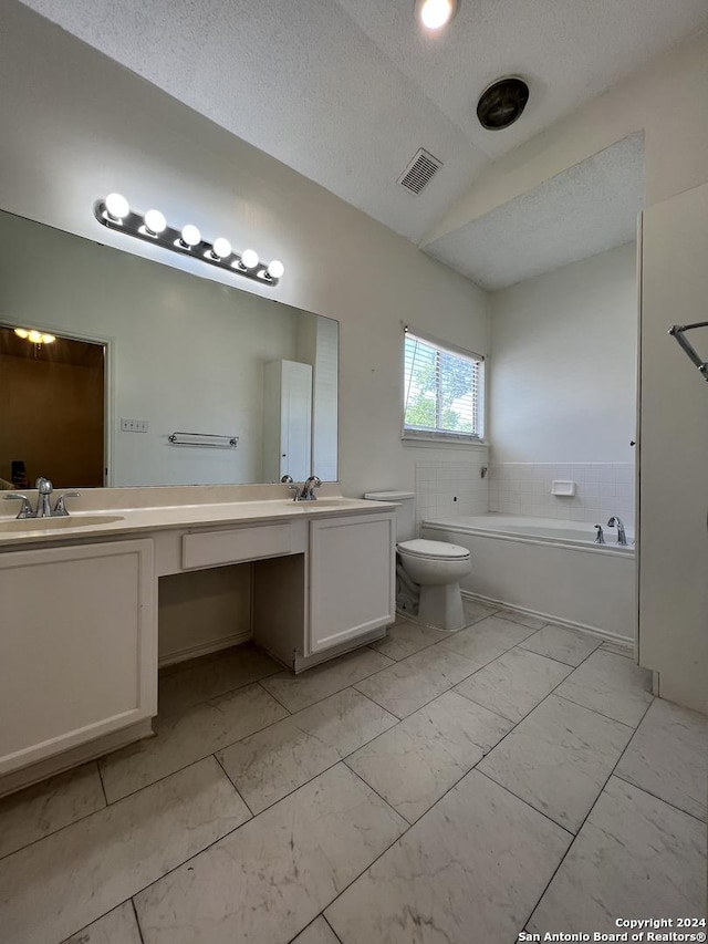 bathroom with toilet, a textured ceiling, a tub to relax in, vanity, and vaulted ceiling