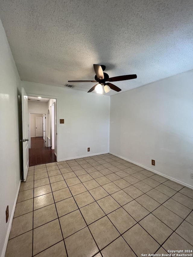 tiled spare room featuring ceiling fan and a textured ceiling