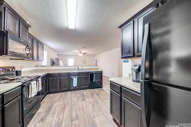 kitchen with dark brown cabinets, ceiling fan, sink, light wood-type flooring, and black appliances