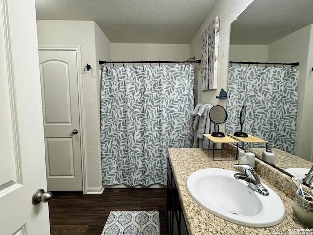 bathroom featuring a shower with curtain, hardwood / wood-style flooring, a textured ceiling, and vanity