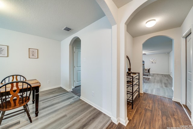 dining space with dark hardwood / wood-style floors and a textured ceiling