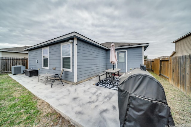 rear view of property with cooling unit, a patio area, and a yard