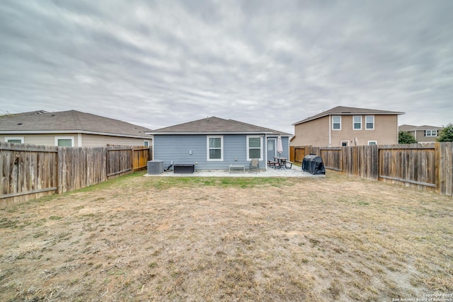 rear view of property featuring a lawn, a patio, and cooling unit