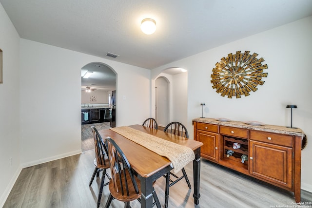 dining area with light hardwood / wood-style floors and ceiling fan