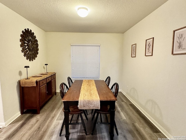 dining area with a textured ceiling and dark hardwood / wood-style floors