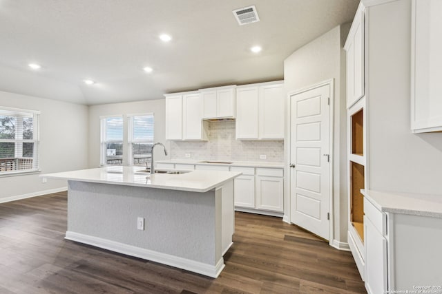 kitchen with white cabinetry, sink, a kitchen island with sink, and dark wood-type flooring