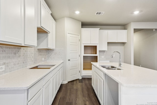 kitchen featuring sink, a kitchen island with sink, dark hardwood / wood-style floors, white cabinets, and decorative backsplash