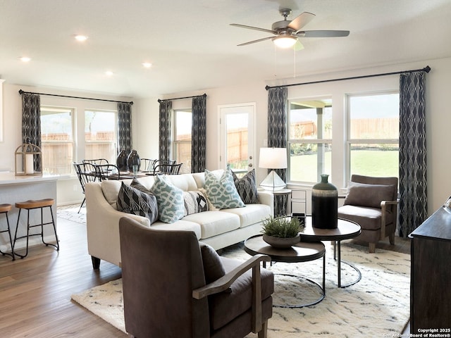 living room with light hardwood / wood-style flooring and ceiling fan