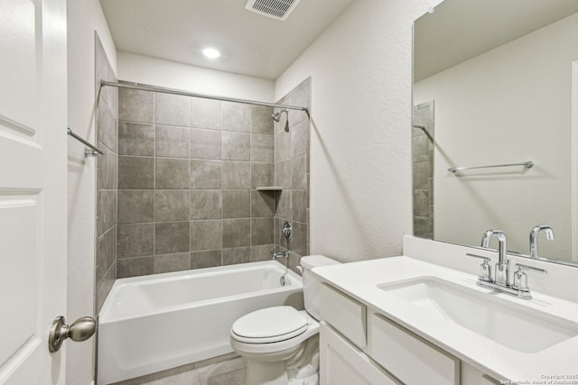 full bathroom with tiled shower / bath, vanity, and toilet