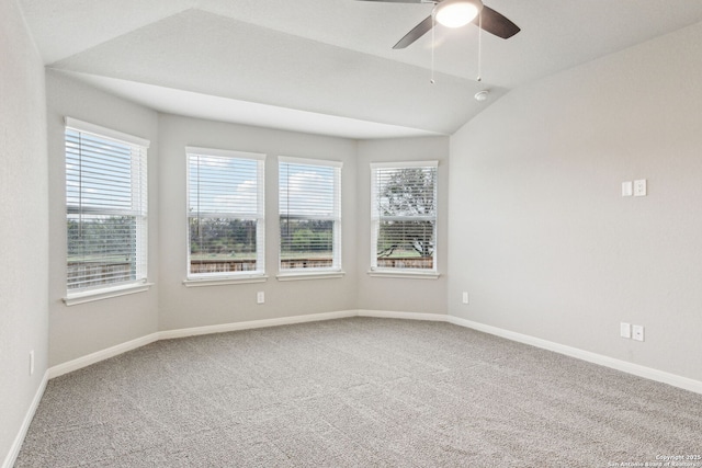 carpeted spare room featuring lofted ceiling, ceiling fan, and a healthy amount of sunlight