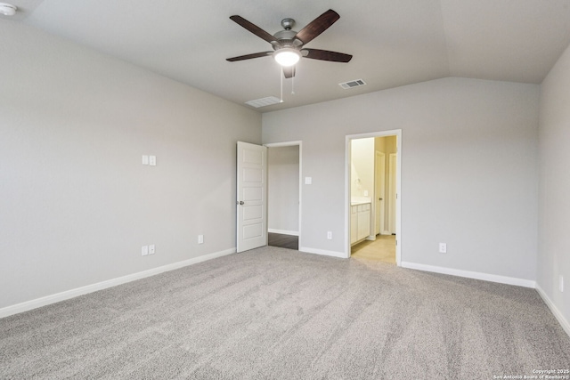 unfurnished bedroom with ceiling fan, light colored carpet, lofted ceiling, and ensuite bath