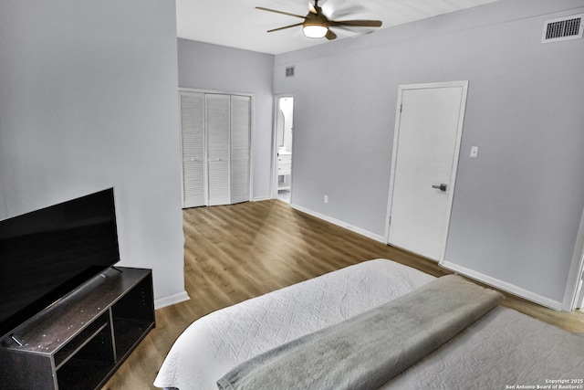 bedroom featuring ceiling fan, dark wood-type flooring, and ensuite bath