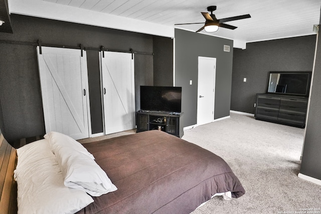 bedroom featuring ceiling fan, carpet floors, and a barn door