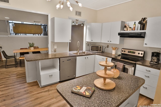 kitchen with light hardwood / wood-style floors, extractor fan, white cabinetry, sink, and stainless steel appliances