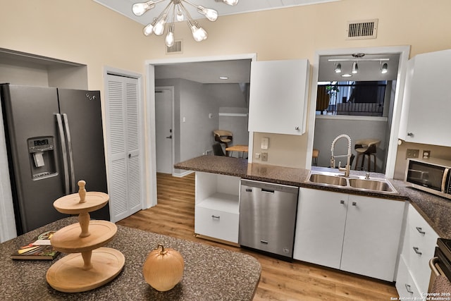 kitchen featuring sink, white cabinetry, a notable chandelier, light hardwood / wood-style floors, and stainless steel appliances