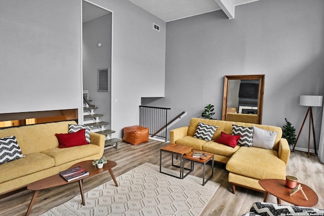 living room featuring light wood-type flooring and beamed ceiling