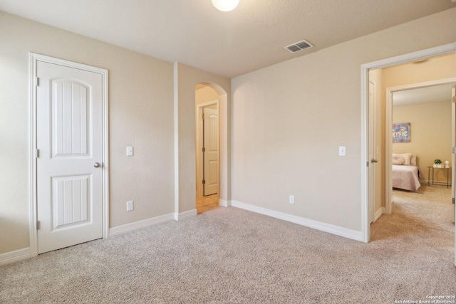 unfurnished bedroom featuring light carpet