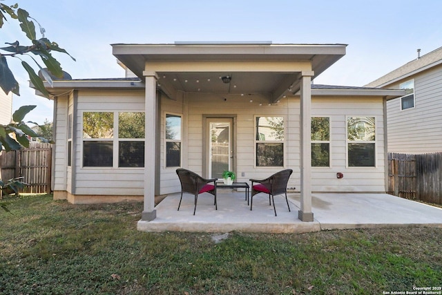 back of house with a patio area and a lawn