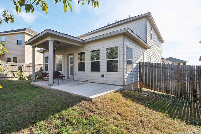 back of property with a patio area and a yard