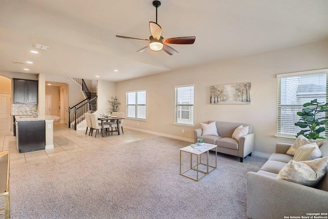 living room with sink, light tile patterned floors, and ceiling fan