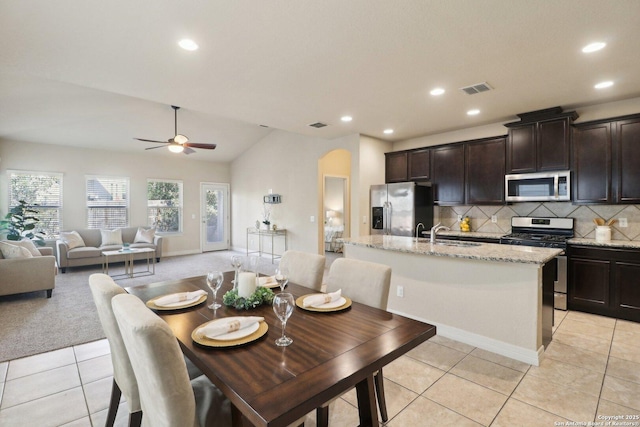 dining room featuring sink, vaulted ceiling, ceiling fan, and light tile patterned floors