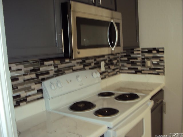 kitchen featuring backsplash, white range with electric stovetop, and light stone countertops