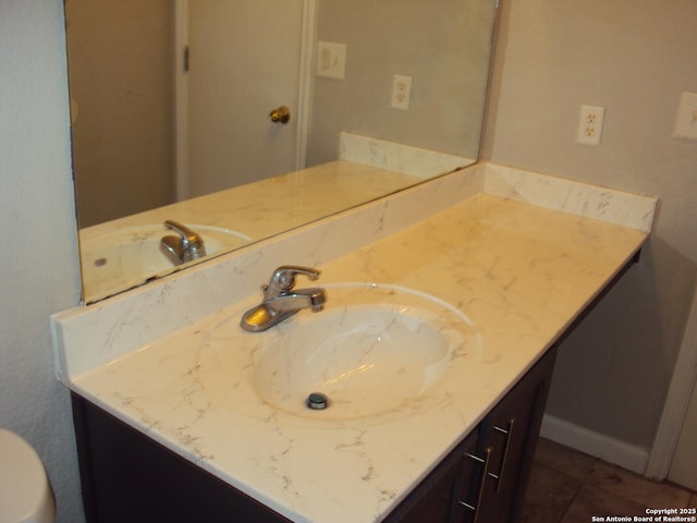 bathroom with toilet, tile patterned floors, and vanity