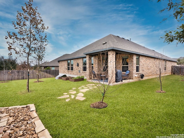 rear view of house featuring a patio area and a yard