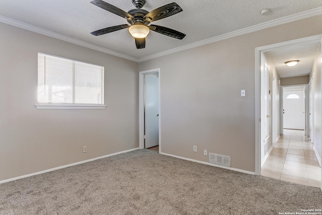 carpeted empty room with ceiling fan, ornamental molding, and a textured ceiling